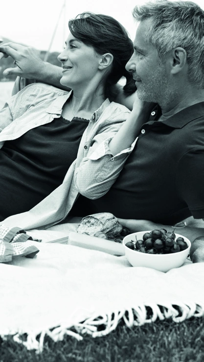 A couple enjoying a meal outdoors, from the dental implant patient brochure.